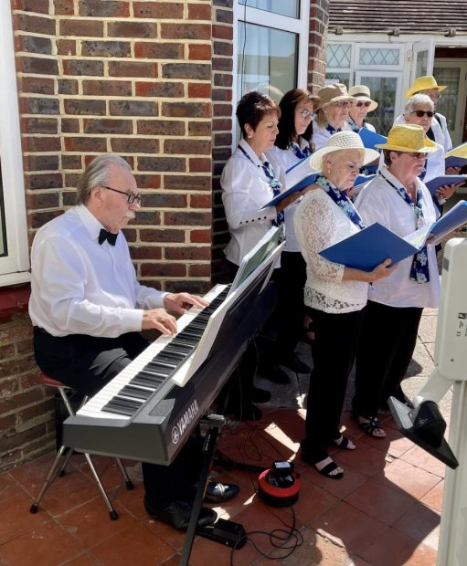 Volunteer choir with a piano singing for the residents