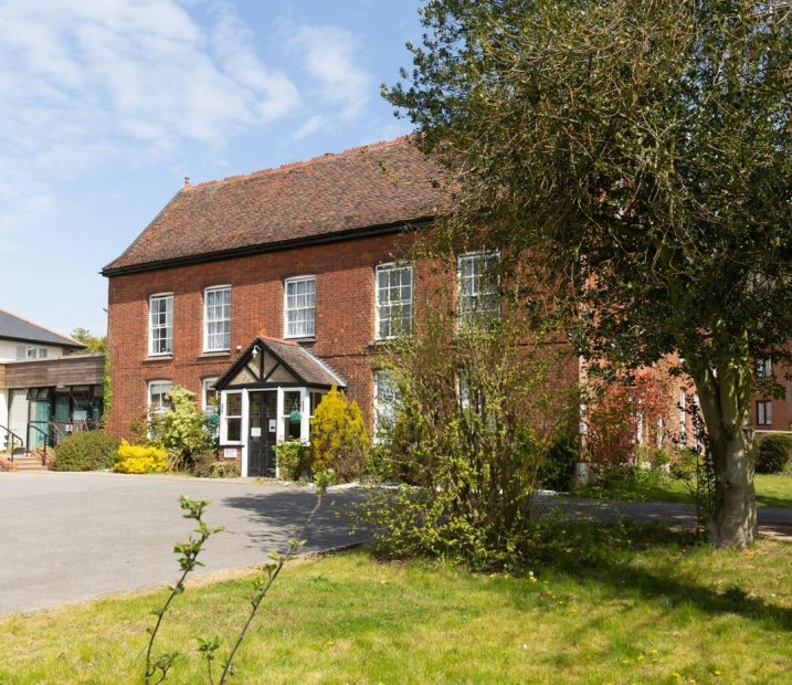 The front of Hillcroft House care home with a garden and some trees
